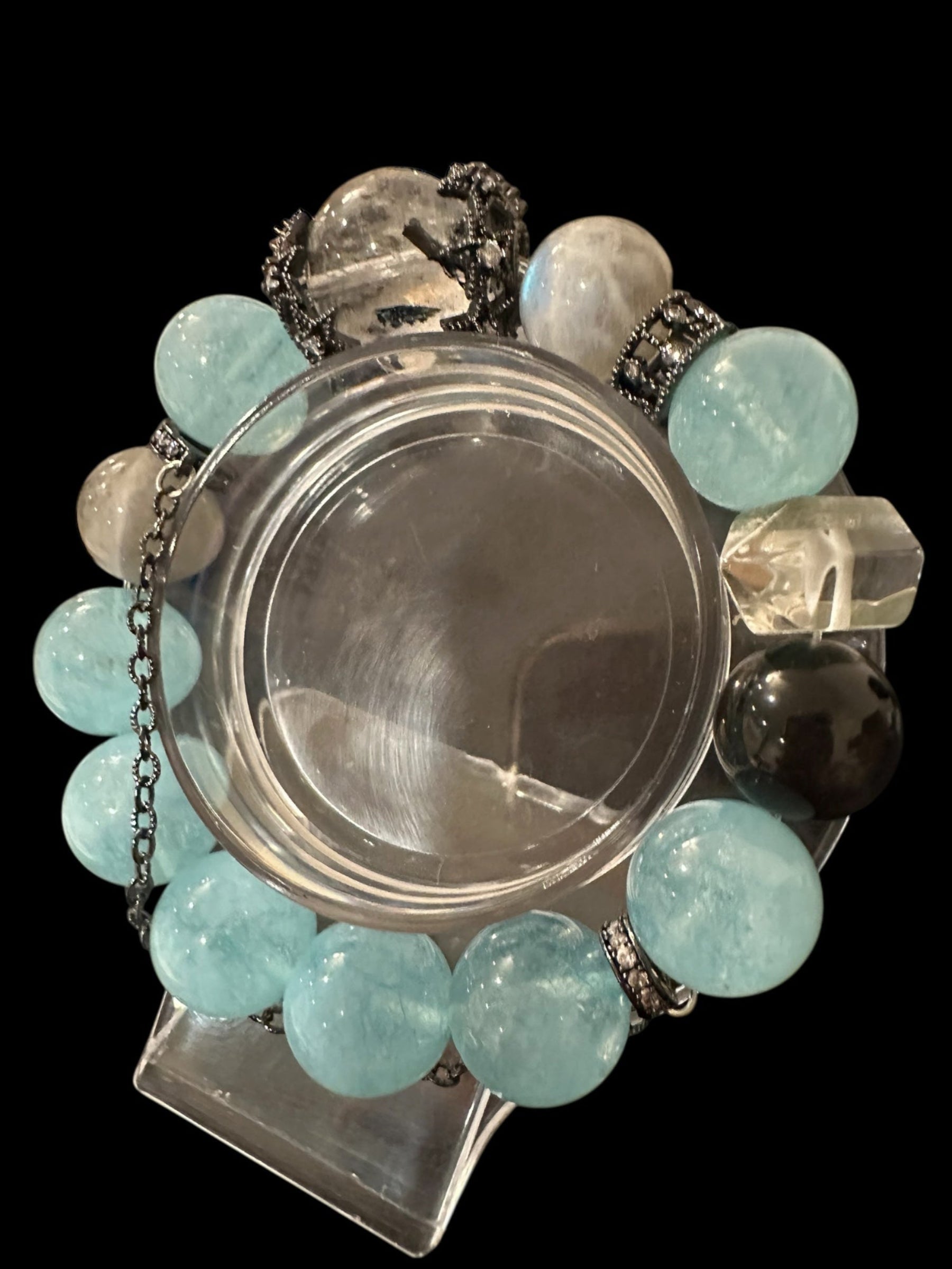 Decorative item with turquoise and clear beads on a black background
